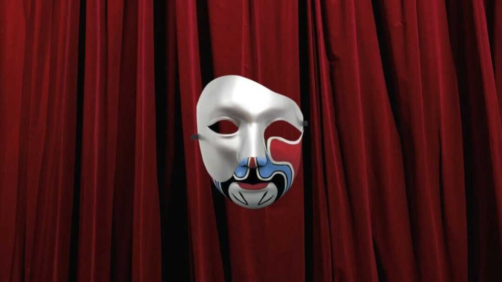 The image shows a stylized mask with intricate blue, black, and red details on a white base. The mask floats against a backdrop of rich, red theater curtains, adding a dramatic flair. The design of the mask suggests a blend of modern and traditional artistic elements, evoking a sense of mystery and performance.